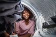 © Samuel B. - Young black African American woman holding a basket of clothes to be washed in a automatic laundry
