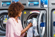 © Samuel B. - Young black African American woman washing her clothes in a automatic laundry