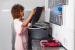 © Samuel B. - Young black African American woman washing her clothes in a automatic laundry