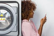 © Samuel B. - Young black African American woman waiting her clothes to be washed in a automatic laundry