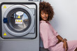 © Samuel B. - Young black African American woman waiting her clothes to be washed in a automatic laundry