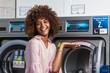 © Samuel B. - Young black African American woman washing her clothes in a automatic laundry