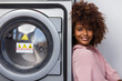 © Samuel B. - Young black African American woman waiting her clothes to be washed in a automatic laundry
