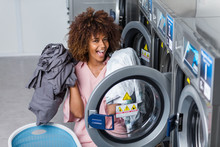 Young Black African American Woman Washing Her Clothes In A Automatic Laundry