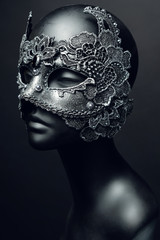 Black head of mannequin in creative metal mask with jewels