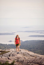 Woman Hiking At Summit Of Pemetic Mountain, Acadia National Park, Maine, USA
