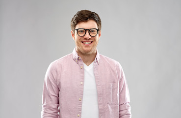 Wall Mural - vision, education and people concept - smiling young man in glasses over grey background