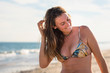 © Cavan Images - Happy woman in bikini at beach