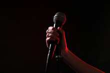 Woman Holding Microphone On Black Background, Closeup