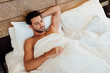 © LIGHTFIELD STUDIOS - overhead view of handsome bearded man lying under blanket with closed eyes