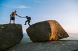 © Cavan Images - Man helping woman across boulder, Pitchoff?Mountain, Adirondack Mountains, New York State, USA