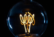 Classic retro incandescent edison light bulb: close up of the glowing filament