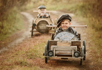 Wall Mural - Competition between the two boys on improvised racing cars