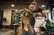 Caucasian woman having her hair styled in a hipster barbershop themes of hairstylist pampering glamour haircare