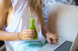 © Cavan Images - Mid section of woman using a laptop while drinking herbal juice