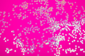 Wall Mural - Holographic stars on trendy pink background. Festive backdrop for your projects.