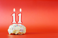 Eleven Years Birthday. Cupcake With White Burning Candle In The Form Of Number 11. Vivid Red Background With Copy Space