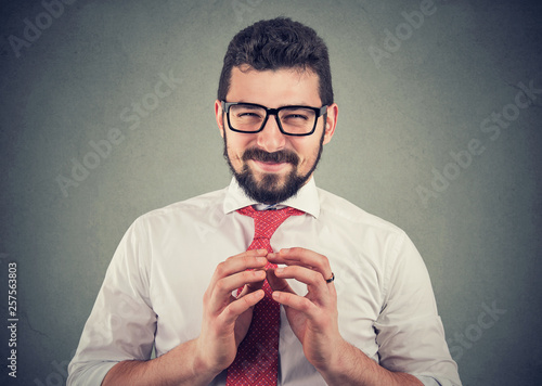 Cuadros en Lienzo Sly businessman in glasses looking at camera plotting a revenge