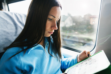 Young women working with tablet in train