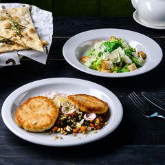 Poster - dinner set lunch in a cafe, meat and caesar salad on black table