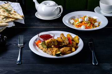 Poster - kebab and sauce on a black table in a cafe restaurant