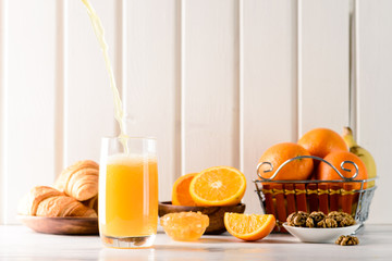 Wall Mural - Delicious continental breakfast with fresh flaky croissants, assorted preserves, orange juice , cereal and coffee, close up on the croissants