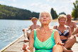 Senioren bei einer Yoga Meditation am See