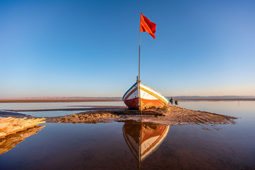 abandoned boat on the bottom of dry salty lake