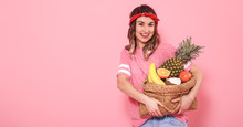 Portrait Of A Girl With A Bag With Fruit Isolated On A Pink Background
