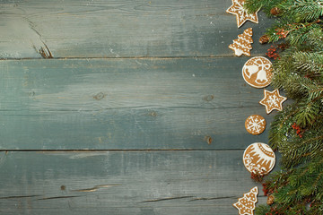 Christmas gingerbread on a blue wooden table decorated with branches of spruce. A Symbol Of Christmas. Festive food. The gingerbread man. Table decoration for the holiday. Christmas card. Empty space