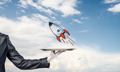Wall Mural - Hand of waiter presenting sketched rocket on tray
