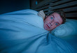 © TheVisualsYouNeed - portrait of young attractive scared man in fear and panic suffering horror nightmare or freezing feeling cold in Winter covering himself with duvet