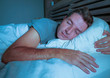 © TheVisualsYouNeed - young attractive and handsome tired man on his 30s or 40s in bed sleeping peacefully and relaxed at apartment bedroom resting comfortable at night