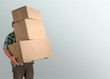 © BillionPhotos.com - Delivery man carrying stacked boxes in front of face against  background
