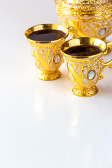 Wall Mural - Still life with traditional golden arabic coffee set with dallah and cup. White background.