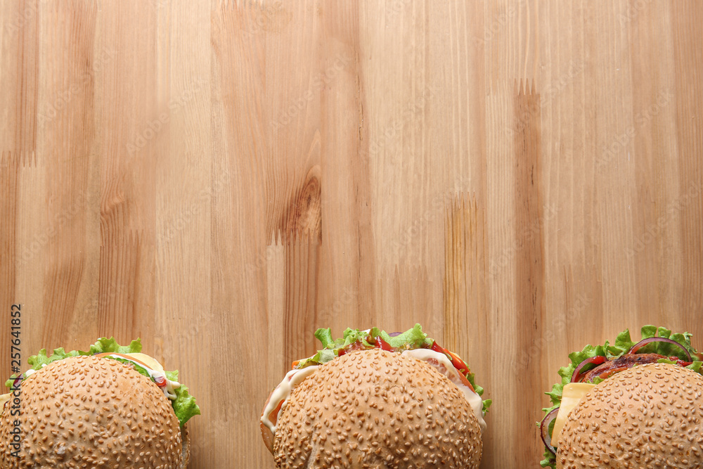 Tasty fresh burgers on wooden table