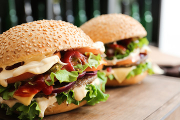 Tasty fresh burgers on table, closeup