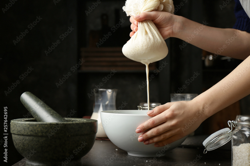 Woman making healthy rice milk in kitchen