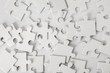 © Pixel-Shot - Heap of white puzzle pieces on light background