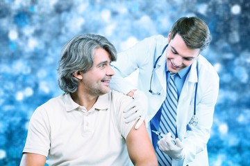 Wall Mural - Handsome doctor making vaccination to male patient on background