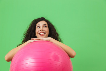 Wall Mural - Photo of happy woman 20s wearing summer clothes doing exercises with fitness ball during aerobics