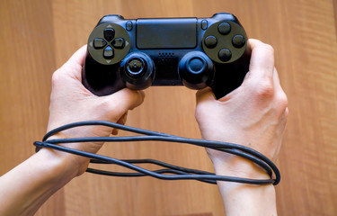 Playing console game addiction concept. Close up of child hands playing the video game. Female or male hands holding console joystick.