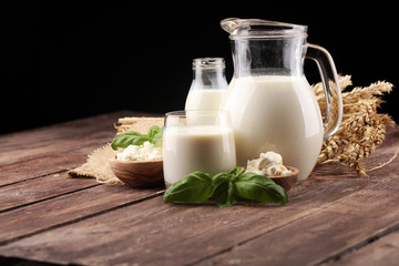 milk products. tasty healthy dairy products on a table. sour cream in a white bowl, cottage cheese bowl, cream in a a bank and milk jar, glass bottle and in a glass