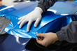 © hedgehog94 - Car wrapping specialist putting vinyl foil or film on car. Selective focus.