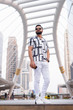 © Ranta Images - Full body shot of bearded Indian man with sunglasses in the city outdoors
