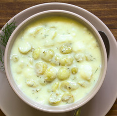 Wall Mural - Traditional Hungarian Piszkeszosz or Piszkemartas, a cooked gooseberry, milk and egg dessert, served in bowl, photographed overhead on dark wood with natural light