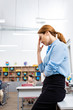 © LIGHTFIELD STUDIOS - Tired teacher in blue blouse standing near table in classroom