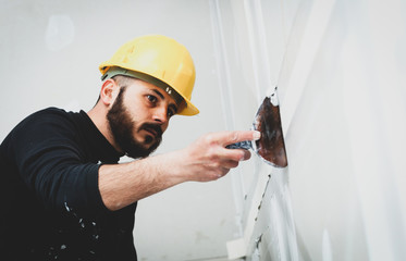 worker plastering gypsum board wall.