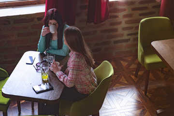 Two female friends having coffee in a cafe