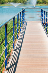 Canvas Print - Blue lake and wooden deck walkway in Bucheon Sangdong Lake Park, Korea